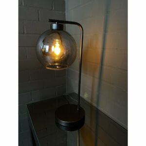 Xandy Tafellamp Black De Xandy Tafellamp Black bestaat uit een zwarte poedercoating frame en een smoke glazen bol. Dit model tafellamp is een unieke moderne lamp die je zowel thuis als op kantoor kan gebruiken. De lamp wordt geleverd met een smoke glazen bol. De afmeting van de lamp vind je onderin: Glas ø20cm Hoogte 50cm Deze Xandy  CASA & VIVENTES Xandy Tafellamp Black kleuren: Zwart, Goud merk: Luxury Living B.V.